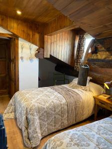 リヴィアにあるApartamento Dúplex Lliviaの木製の壁のベッドルーム1室(ベッド2台付)