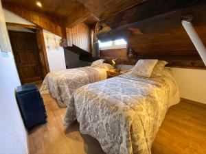 2 camas en una habitación con paredes de madera en Apartamento Dúplex Llivia, en Llivia