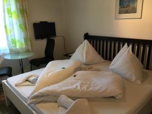 a bed with white sheets and pillows on it at Haus Lechner Apartments in Sankt Jakob in Haus