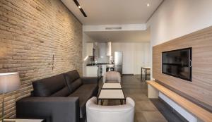 a living room with a couch and a brick wall at Mon Suites San Martin in Valencia