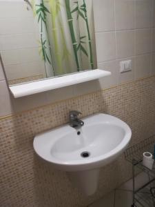 een witte wastafel in een badkamer met een spiegel bij Trilocale Alba Adriatica a 500 m dal mare in Alba Adriatica