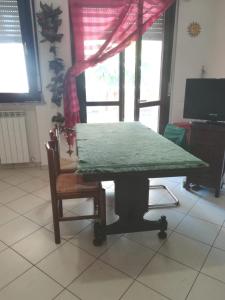een tafel in een kamer met een stoel en een raam bij Trilocale Alba Adriatica a 500 m dal mare in Alba Adriatica