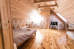 una camera con un letto in una casa di legno di Willow Apts a Junoszyno