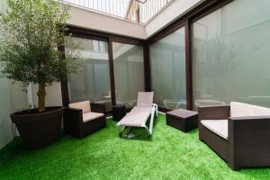 een kantoor met groen gras, stoelen en ramen bij Morar Apartments Porto in Porto