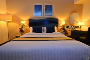 سرير أو أسرّة في غرفة في Harbour Suites Hotel
