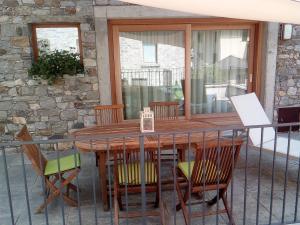 a wooden table and chairs on a balcony at merian in Piuro