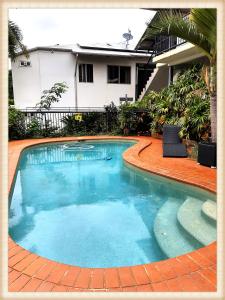 - une piscine en face d'une maison dans l'établissement Childers Oasis Motel, à Childers