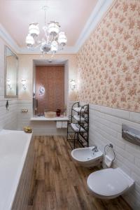 a bathroom with two toilets and a tub and a sink at Trezzini Art Hotel in Saint Petersburg