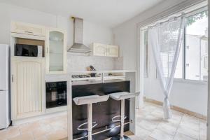 een keuken met witte kasten en witte apparaten bij Le Narbona in Narbonne