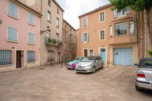 een parkeerplaats met auto's voor gebouwen bij Le Narbona in Narbonne