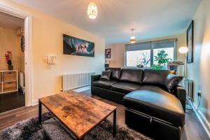 a living room with a leather couch and a table at 1 Bd Apt in Historical W Belfast Close to Centre in Belfast