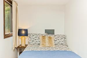 1 dormitorio con cama, lámpara y ventana en Girdwood Mountain House en Girdwood
