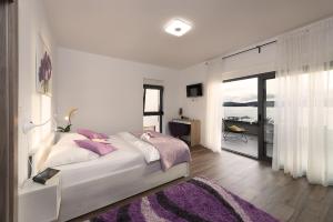 a bedroom with a large bed with a purple rug at Villa Lu-Ma Beachfront with Heated Pool in Turanj