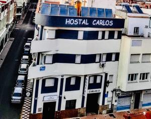 un edificio con un cartel de carolis de hospital en Hostal Carlos 2, en La Línea de la Concepción