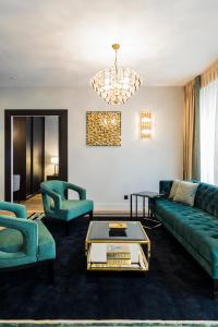 a living room with green furniture and a chandelier at Luxury Apartment Paris Louvre II in Paris