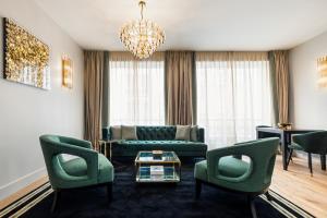 Luxury Apartment Paris Louvre II في باريس: غرفة معيشة بأثاث أخضر وثريا