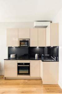 uma cozinha com armários brancos e bancadas pretas em Luxury Apartment Paris Louvre II em Paris