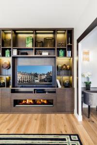 ein Wohnzimmer mit einem TV und einem Kamin in der Unterkunft Luxury Apartment Paris Louvre II in Paris