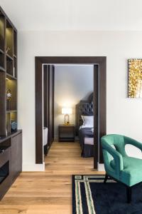 - une chambre avec une chaise verte et un lit dans l'établissement Luxury Apartment Paris Louvre II, à Paris