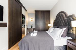 a bedroom with a large bed with a large headboard at Luxury Apartment Paris Louvre II in Paris