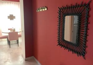 a mirror on a red wall in a room at Ritual Sevilla Suites Alameda 1 in Seville