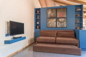 a living room with a couch and a tv at Roots Dhermi in Dhërmi
