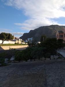 eine Straße mit einem Haus und einem Berg im Hintergrund in der Unterkunft Royal@Sea2 in Muizenberg