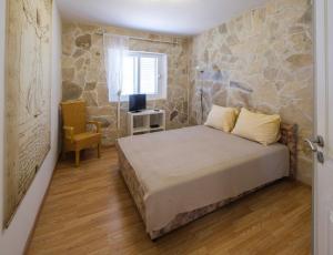 a bedroom with a bed with a stone wall at Apartments Kaktus Orebic in Orebić