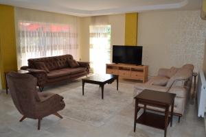 a living room with couches and a flat screen tv at Antalya belek private villa private pool 4 bedrooms close to beach park - land of legends in Belek