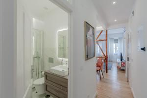 ein weißes Badezimmer mit einem Waschbecken und einem Spiegel in der Unterkunft Príncipe Real Flamingo Residence in Lissabon