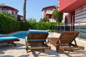 two chairs and a table next to a swimming pool at Antalya belek private villa private pool 4 bedrooms close to beach park - land of legends in Belek