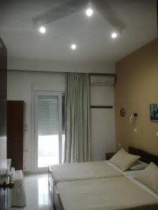 a hotel room with two beds and a window at Hotel Dimitra Sun in Archangelos