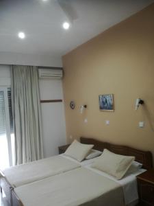 アルハンゲロスにあるHotel Dimitra Sunのベッドルーム1室(ベッド2台、窓付)
