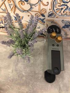 a vase of purple flowers and a pot of gold coins at Aviator Boutique Residence in Otopeni