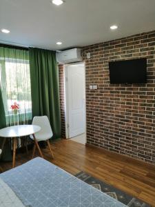 a living room with a brick wall and a tv at Studio Claudia-self Check-in in Brăila