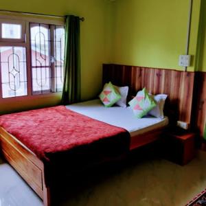 a bedroom with a large bed with a red blanket at Orchid Lodge kalimpong in Kalimpong