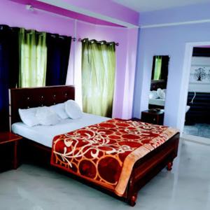 a bedroom with a bed with a red and white comforter at Orchid Lodge kalimpong in Kalimpong