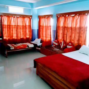 a bedroom with two beds and red curtains at Orchid Lodge kalimpong in Kalimpong