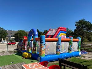 um parque infantil com uma colorida estrutura insuflável em Camping De Collignon em Cherbourg en Cotentin