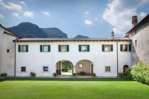 a large white house with a green yard at Villa Brignoli in Rivalta di Brentino