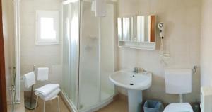 uma casa de banho branca com um lavatório e um chuveiro em B&B Corte Campana em Veneza