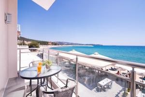 a balcony with a table and a view of the ocean at Xenia Suites in Limenaria