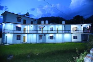 ein großes weißes Haus mit Lichtern in der Nacht in der Unterkunft Jeet Palace in Uttarkāshi