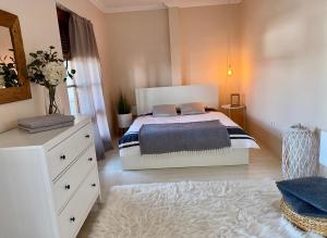 Un dormitorio con una cama y un tocador con un jarrón de flores en Apartmán Rea, en Komárno