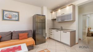Rona Apartment Andy في نوفاليا: غرفة معيشة مع أريكة ومطبخ