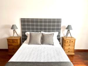 um quarto com uma cama com duas mesas de cabeceira em Brick Ocean Apartment em Nazaré
