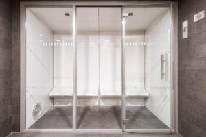 a glass shower stall with a toilet in a bathroom at Hotel Girassol - Suite Hotel in Funchal