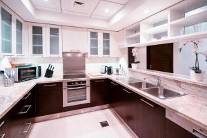 a large kitchen with a sink and a microwave at Elite Royal Apartment - Onyx in Dubai
