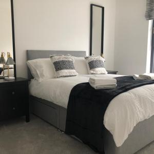 a bedroom with a large bed with white sheets and pillows at Luxury apartment in the heart of Portrush Main St in Portrush