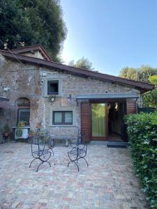 uma casa de pedra com cadeiras em frente em Casetta Santa Fortunata Guest House em Sutri